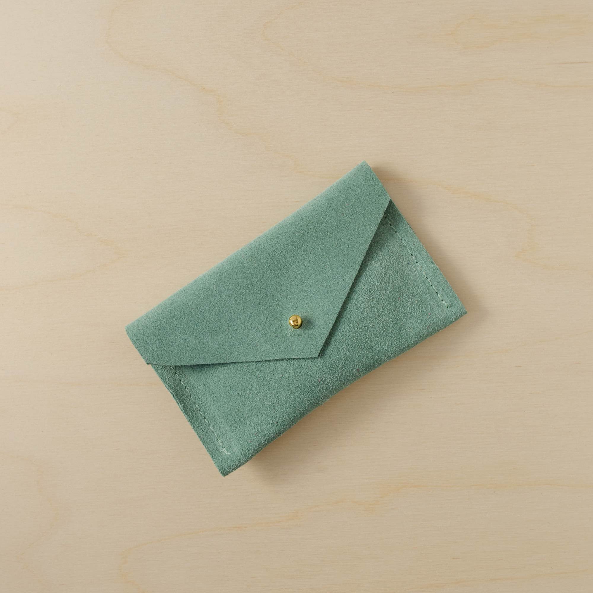 A suede Small Notions Pouch in Mint Green. Complete with a stud for secure closing.