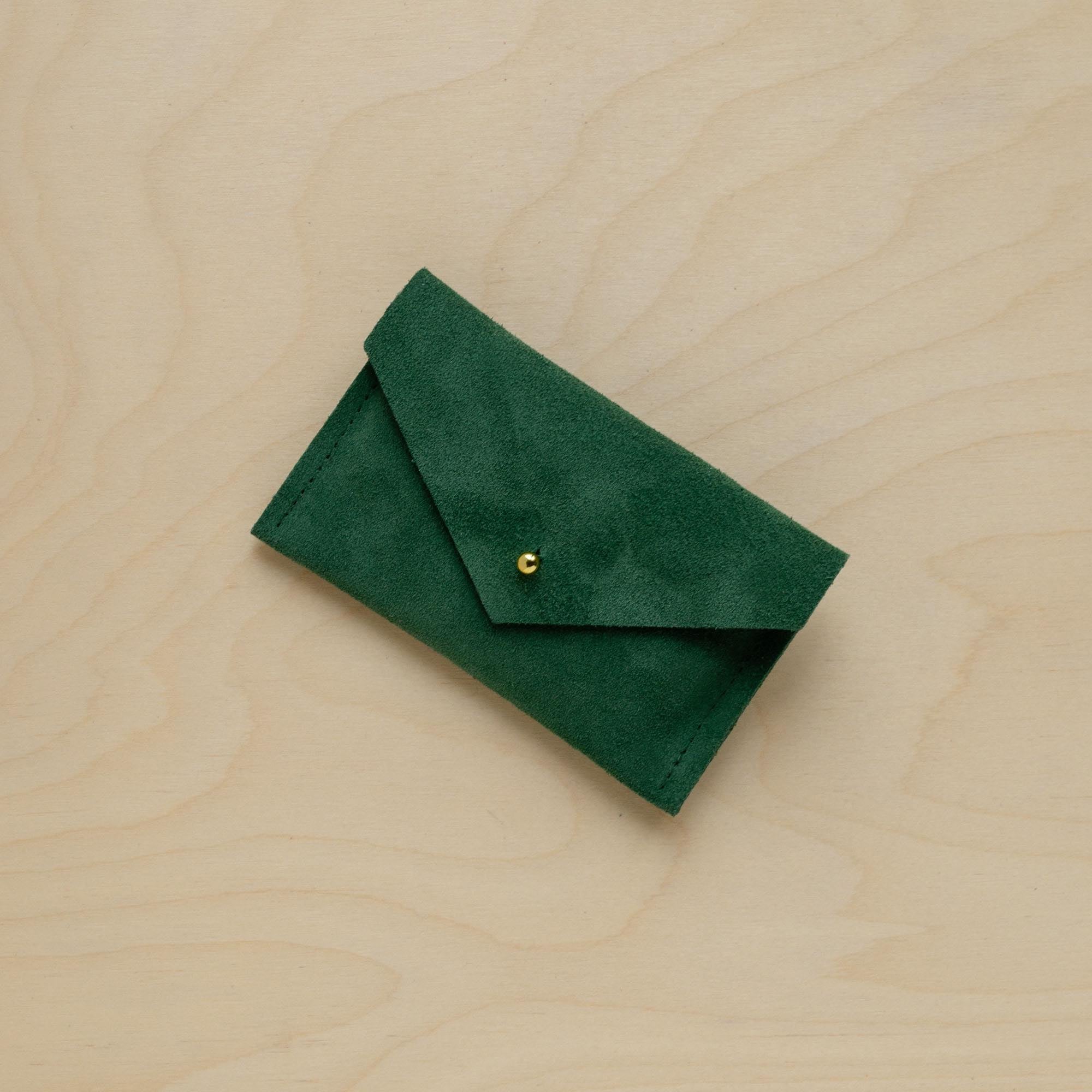 A suede Small Notions Pouch in Moss Green. Complete with a stud for secure closing.