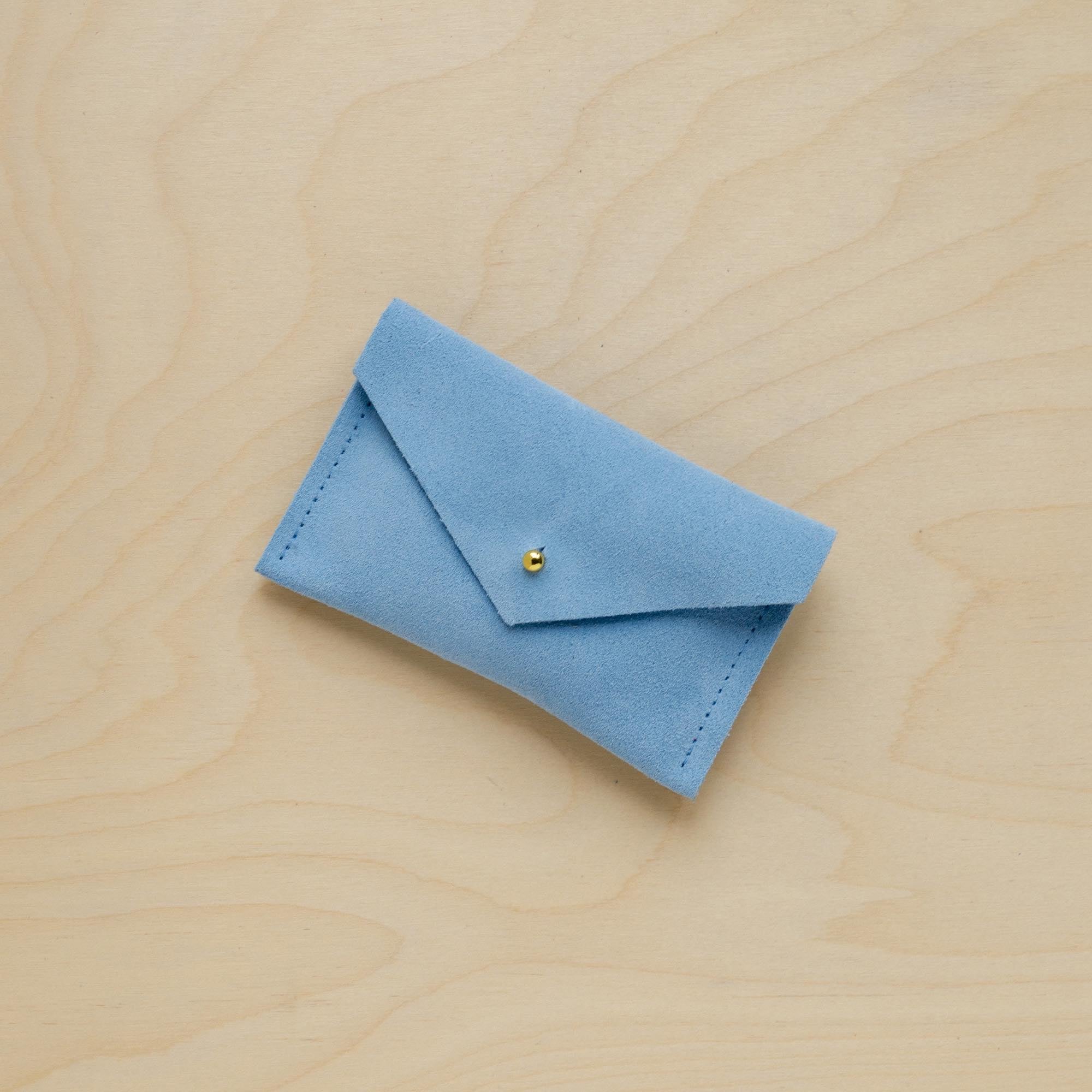A suede Small Notions Pouch in Pale Blue. Complete with a stud for secure closing.