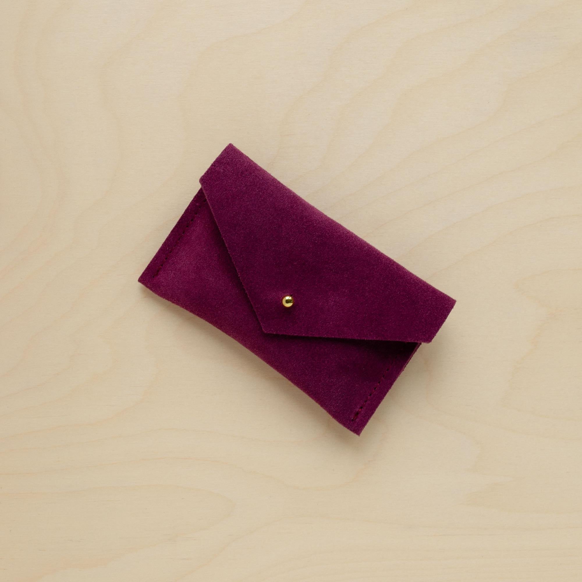A suede Small Notions Pouch in Plum Purple. Complete with a stud for secure closing.