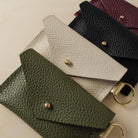 Four leather keyring card holders in, Metallic Berry, Black, Cream and Olive Green. 