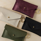 Four leather keyring card holders in black, Metallic Berry, Cream and Olive Green