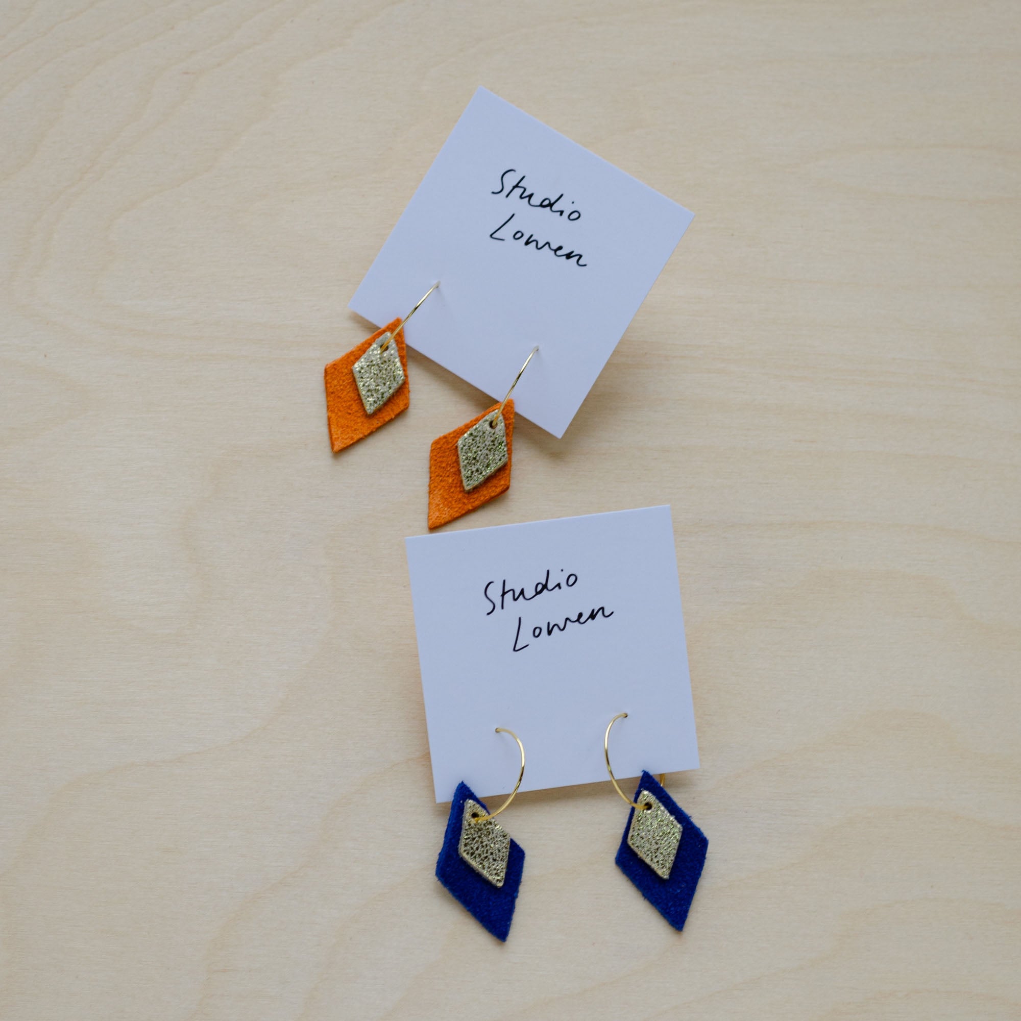 Two pairs of the Lia Hoop Earrings in Ultramarine Blue and Clementine Orange.