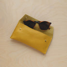 Mustard Yellow leather glasses case with sunglasses.