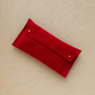 The suede pen case in Crimson Red. Featuring a double stud. 