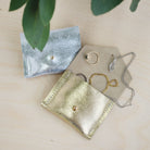 Gold and Silver Jewellery Pouches with rings, bracelets and necklaces inside.