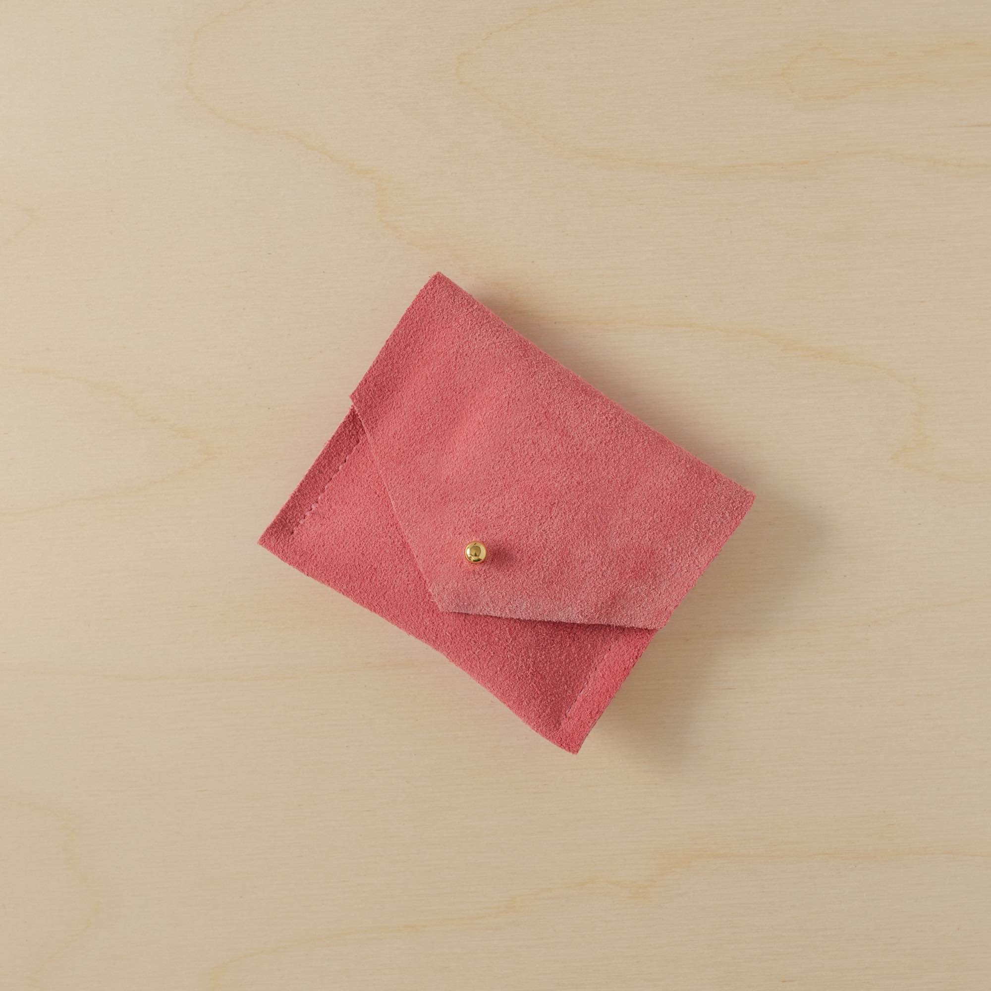 A suede Stitch Markers pouch in Coral Pink. Complete with a stud for secure closing.