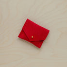 A suede Stitch Markers pouch in Crimson Red. Complete with a stud for secure closing.