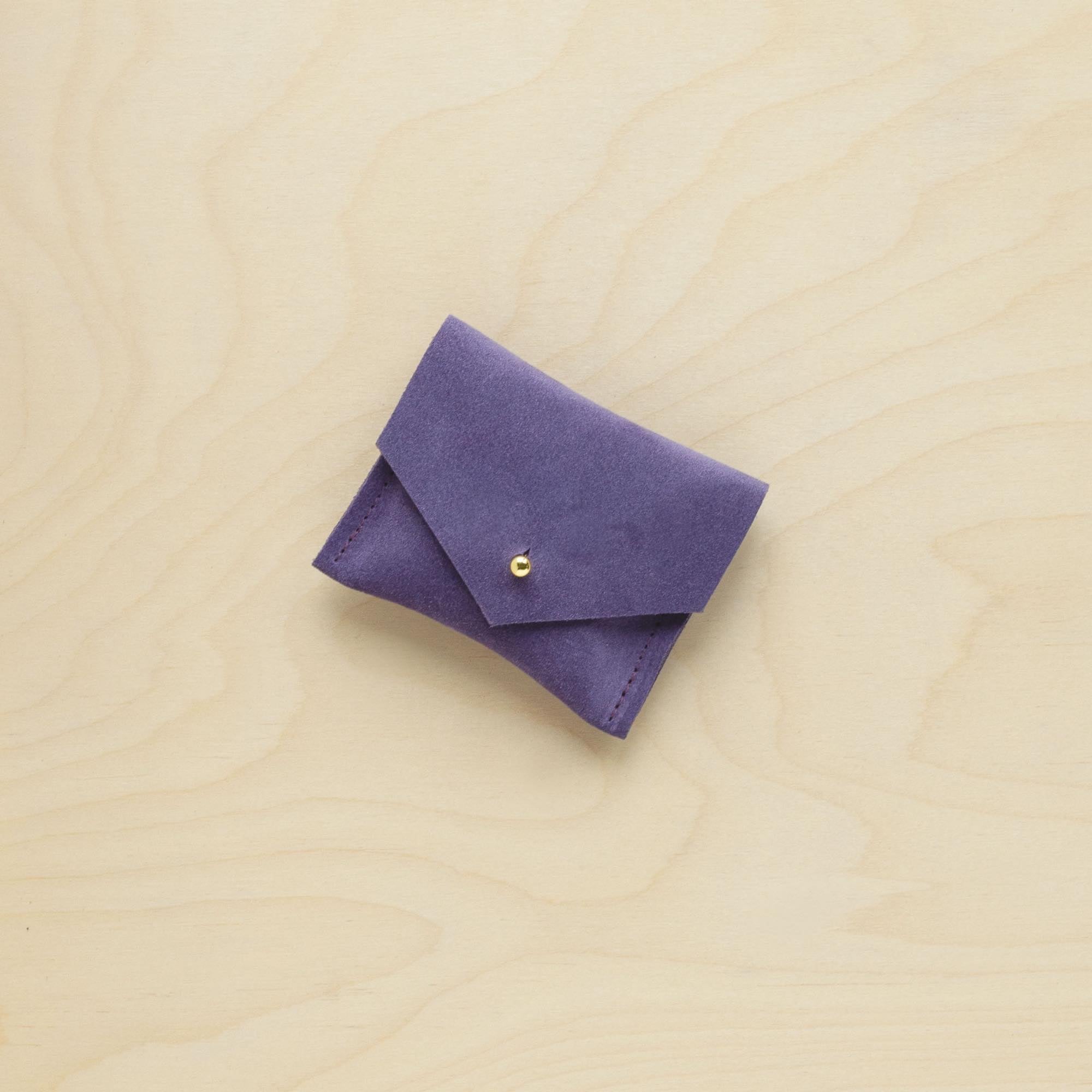 A suede Stitch Markers pouch in Grape Purple. Complete with a stud for secure closing.