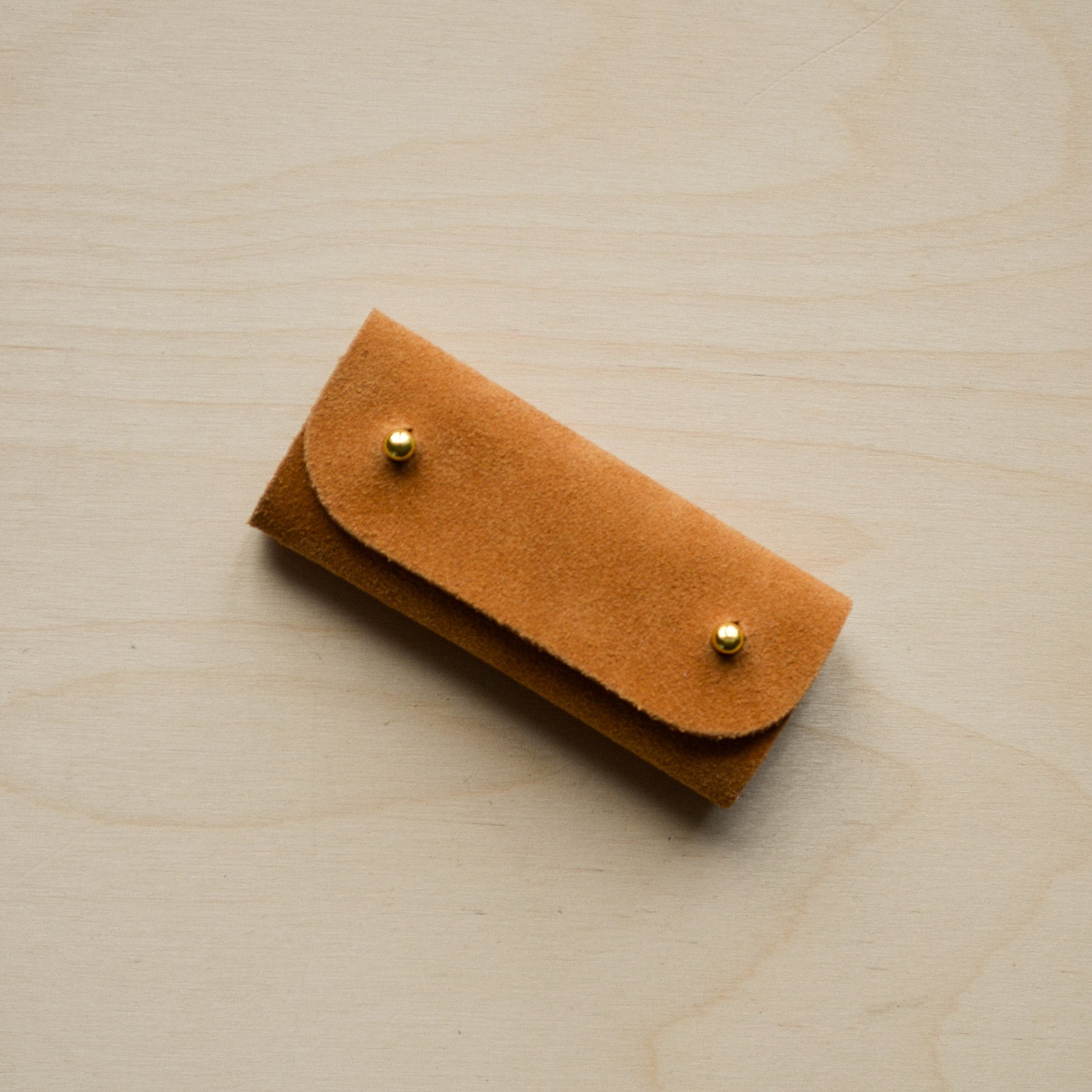 Tan brown mini sewing needle case.