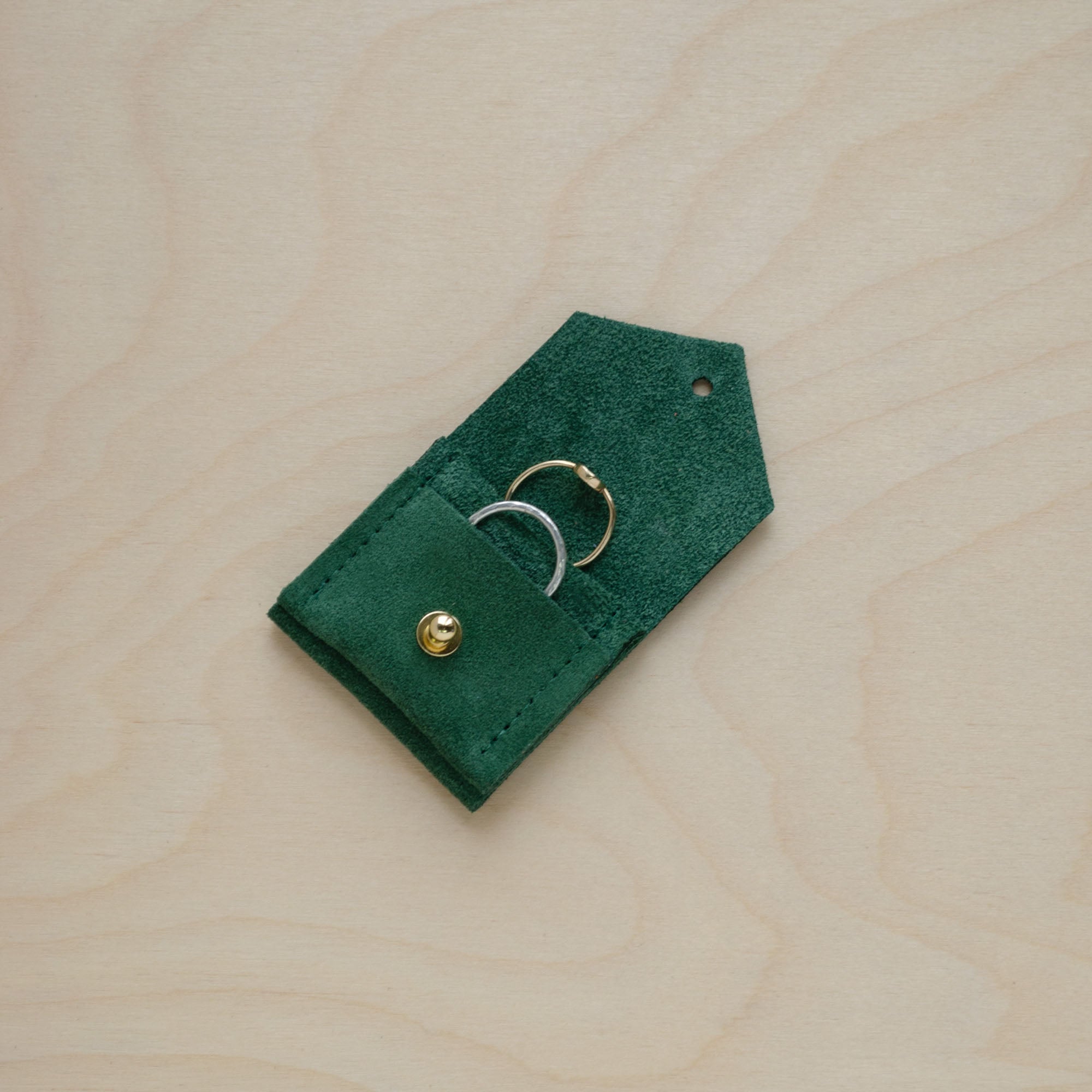 An open and in use, Moss Green Wedding Ring Pouch in suede.
