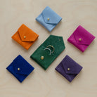 Six wedding ring pouches from the suede colour range. Featuring, Pale Blue, Clementine Orange, Fuchsia Pink, Moss Green, Ultramarine Blue and Grape Purple.