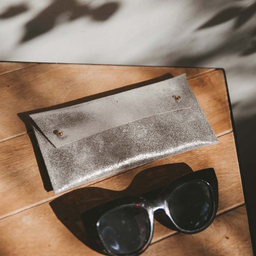 Silver leather glasses cases on wooden table