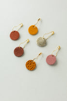 Colourful leather and suede stitch markers for knitting in oranges and browns.