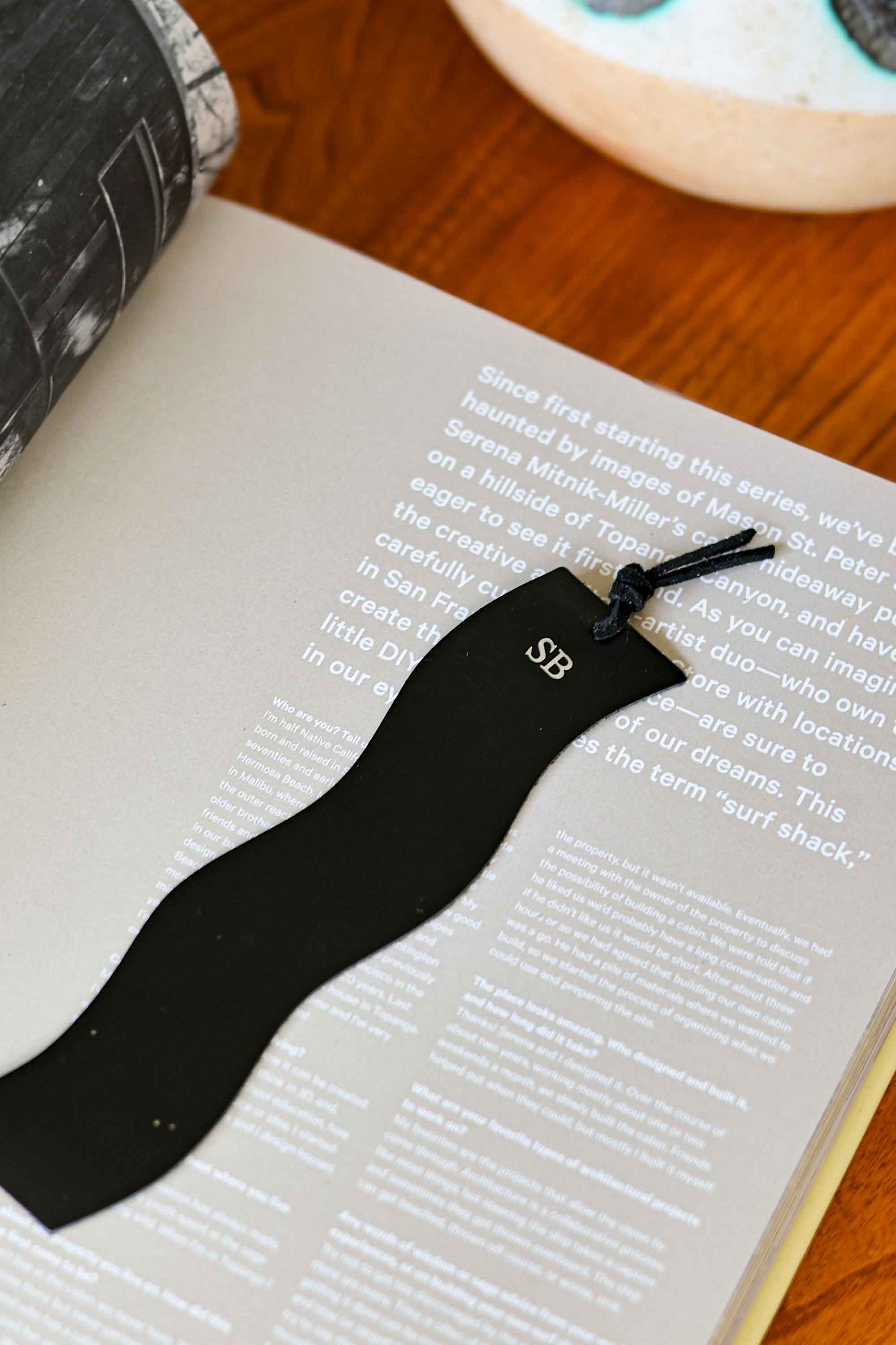 Black wavy shape bookmark with initials on a book