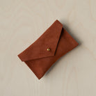 A suede Small Notions Pouch in Chestnut Brown. Complete with a stud for secure closing.