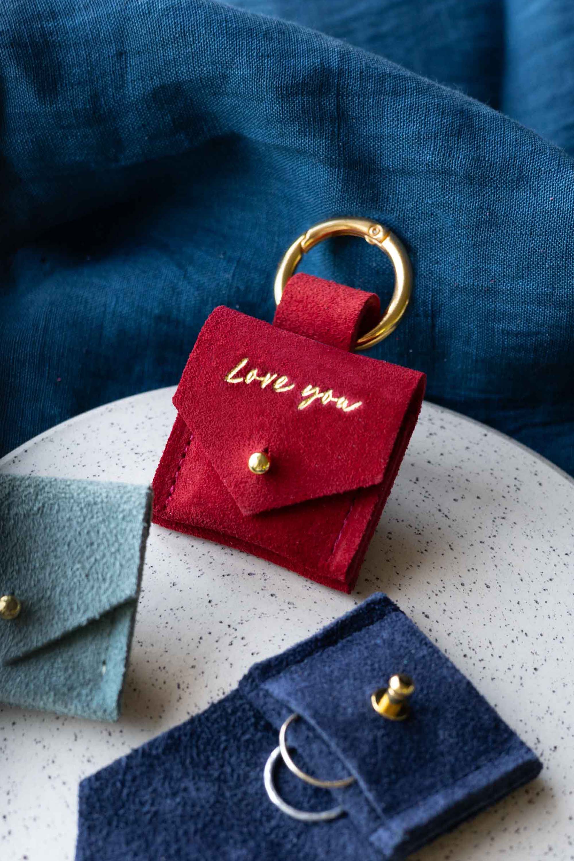 Red suede pouch with clip and "I love you" on it.